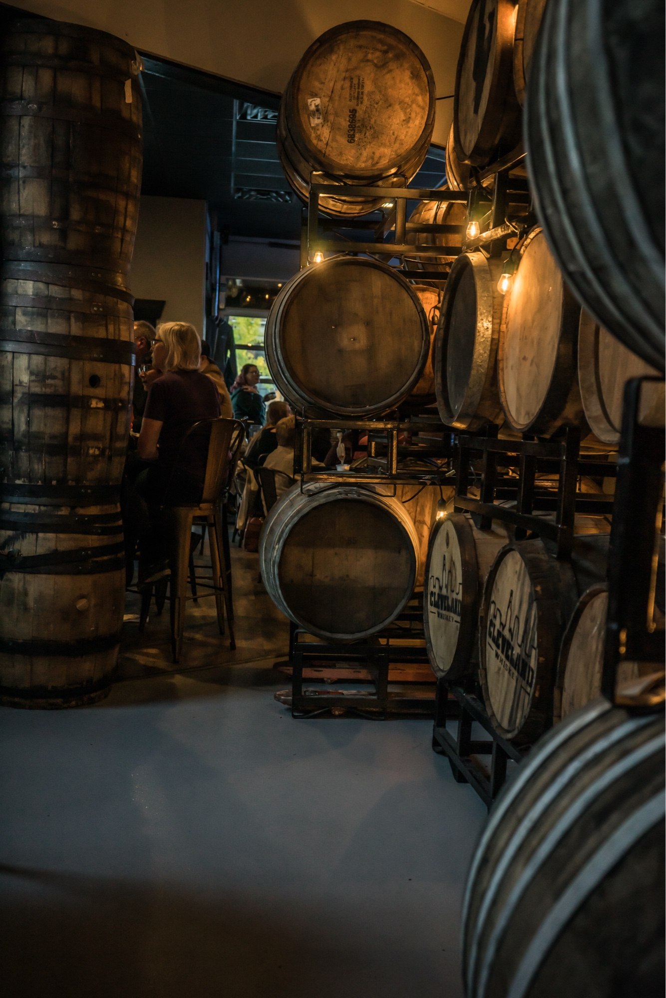 The barrel room at Wild Side Brewing, stacked whiskey barrels strung with lights